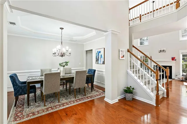 a view of a dining room with furniture a chandelier and wooden floor