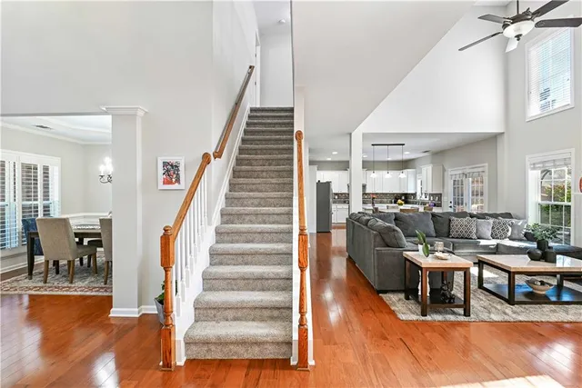 a living room with furniture and a dining table with wooden floor