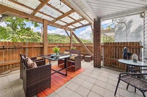 a living room with patio furniture and a grill