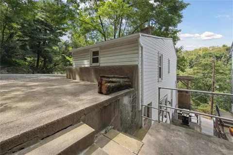 a backyard of a house with barbeque oven and bench