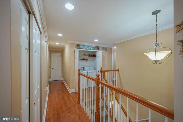 a view of a hallway with wooden floor and staircase