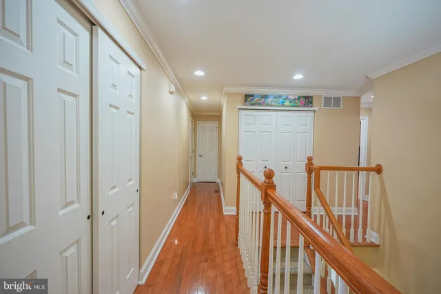 a view of a hallway with wooden floor and staircase