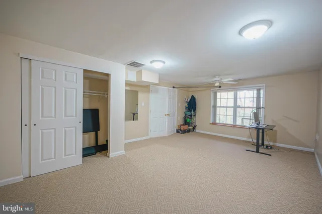 an empty room with windows and mirror