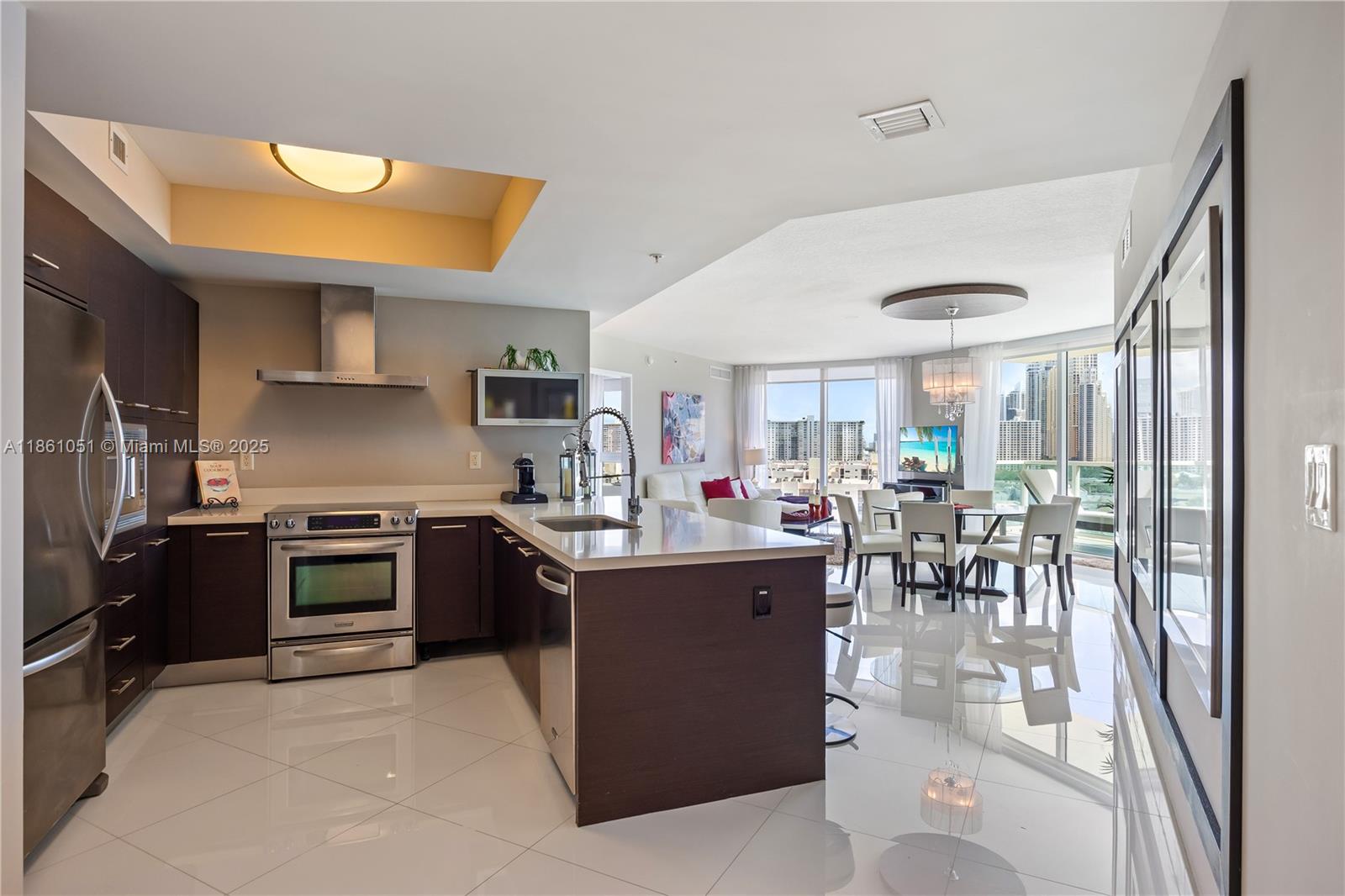250 Sunny Isles Boulevard, Unit 31202 Sunny Isles Beach, FL 33160 - Photo 7 of 28 a kitchen with stainless steel appliances granite countertop a stove top oven a sink a dining table and chairs