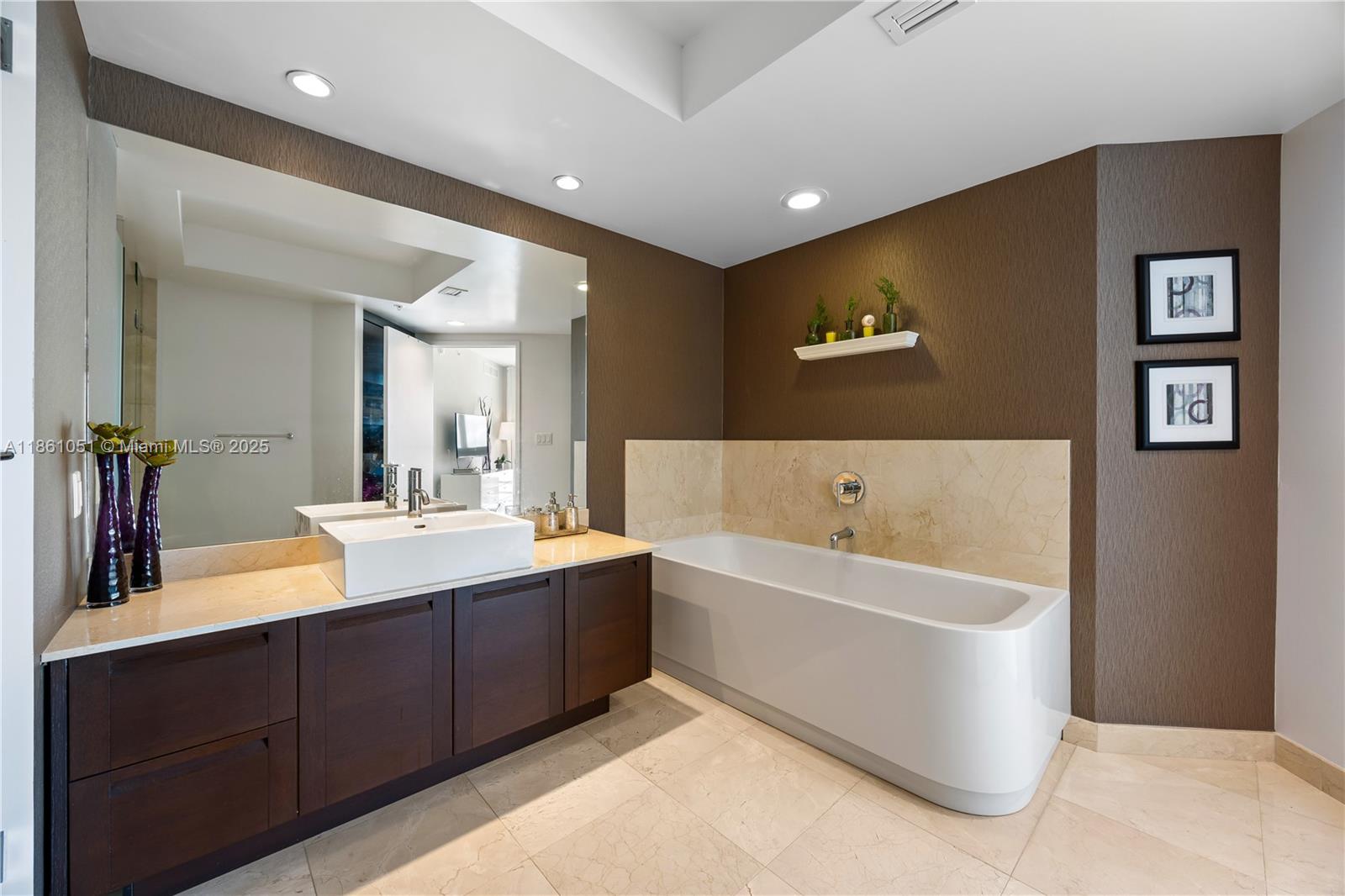 250 Sunny Isles Boulevard, Unit 31202 Sunny Isles Beach, FL 33160 - Photo 10 of 28 a bathroom with a bathtub double vanity sink and mirror