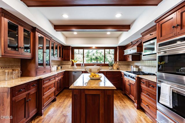 a kitchen with stainless steel appliances granite countertop a stove and a microwave