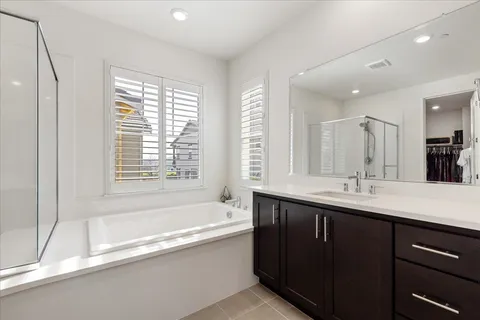 a spacious bedroom with a bed and a flat screen tv