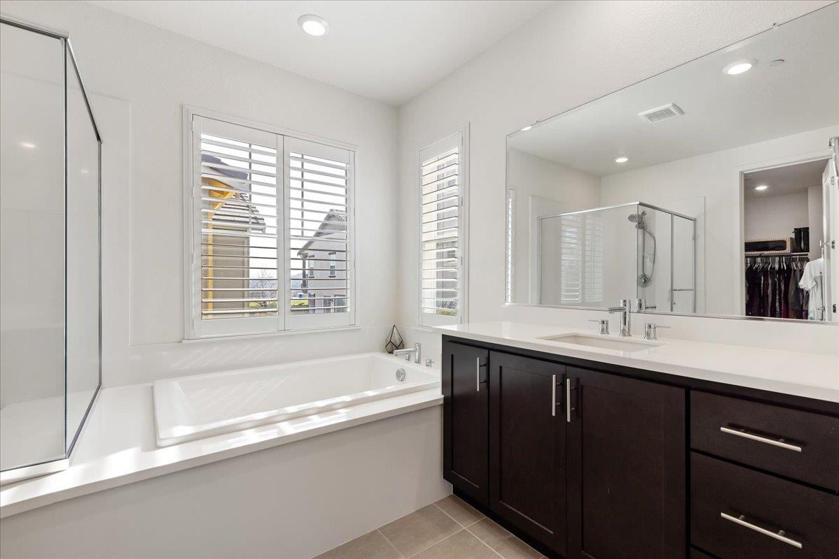 2005 Davoli Court San Ramon, CA 94583 - Photo 23 of 45 Bathroom featuring a spacious closet, double vanity, a garden tub, a stall shower, and light tile patterned floors