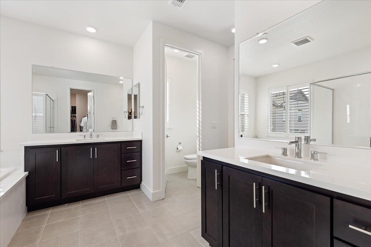 2005 Davoli Court San Ramon, CA 94583 - Photo 25 of 45 Full bath with two vanities, a shower stall, light tile patterned floors, a bath, and recessed lighting