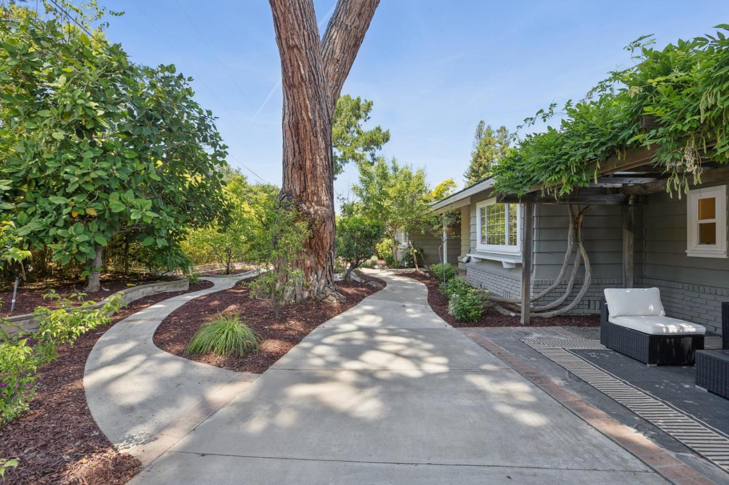 755 Santa Rita Avenue Los Altos, CA 94022 - Photo 5 of 50 a view of a backyard with table and chairs potted plants and large tree