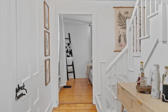 a view of a hallway with wooden floor and staircase