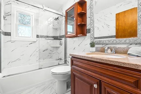 a bathroom with a granite countertop sink toilet and shower