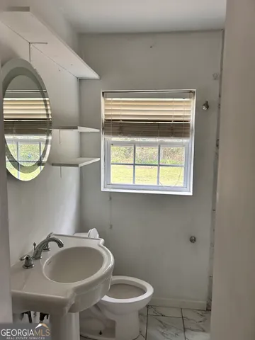 an empty room with wooden floor and entrance