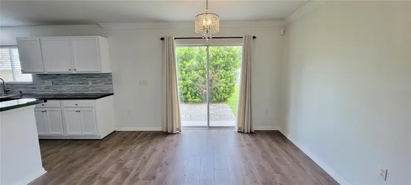 a view of a kitchen with wooden floor electronic appliances and window