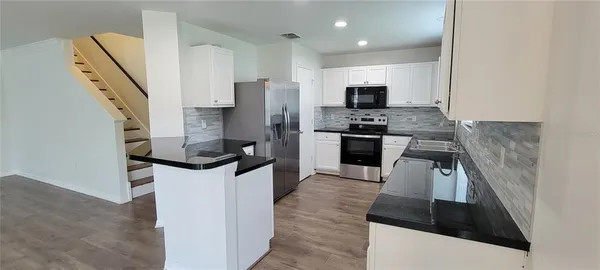 a kitchen with stainless steel appliances a stove refrigerator sink and microwave