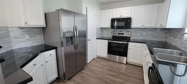 a kitchen with a refrigerator stove and microwave