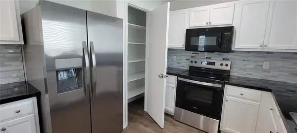 a kitchen with stainless steel appliances granite countertop a refrigerator stove and microwave