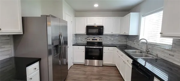 a kitchen with a refrigerator sink and microwave
