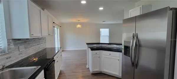 a kitchen with stainless steel appliances granite countertop a refrigerator and a sink