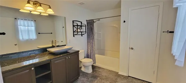 a spacious bathroom with a granite countertop sink toilet and shower