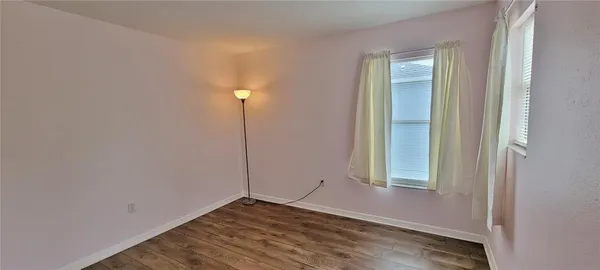 a view of an empty room with closet and a window