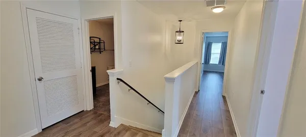 a view of a hallway with wooden floor and entryway