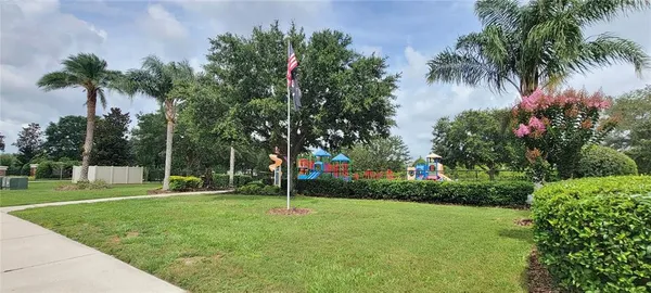 a front view of a house with a garden and trees