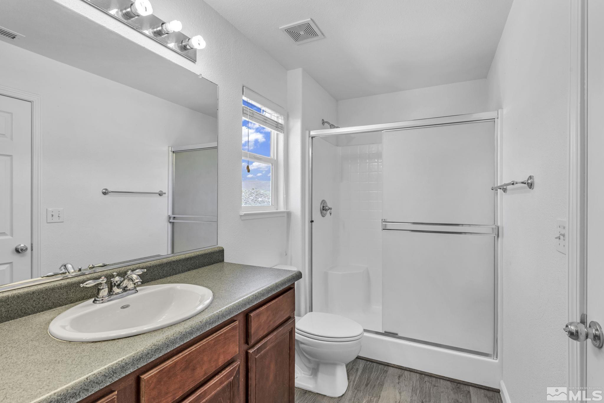 5869 September Circle Reno, NV 89523 - Photo 12 of 21 a bathroom with a granite countertop sink toilet a mirror a vanity and shower