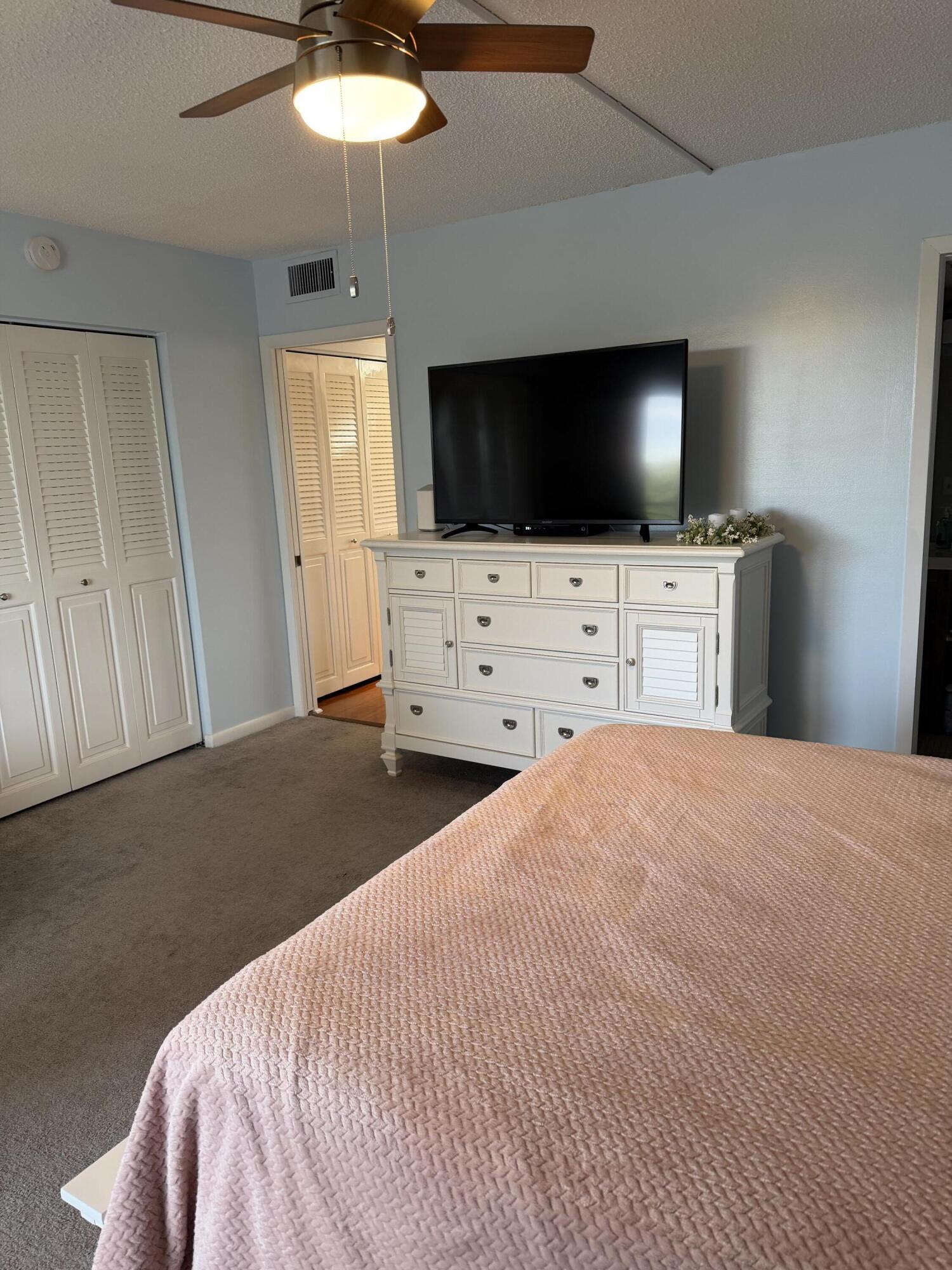 3062 Ainslie Drive Boca Raton, FL 33434 - Photo 21 of 27 a bedroom with a bed and a flat screen tv