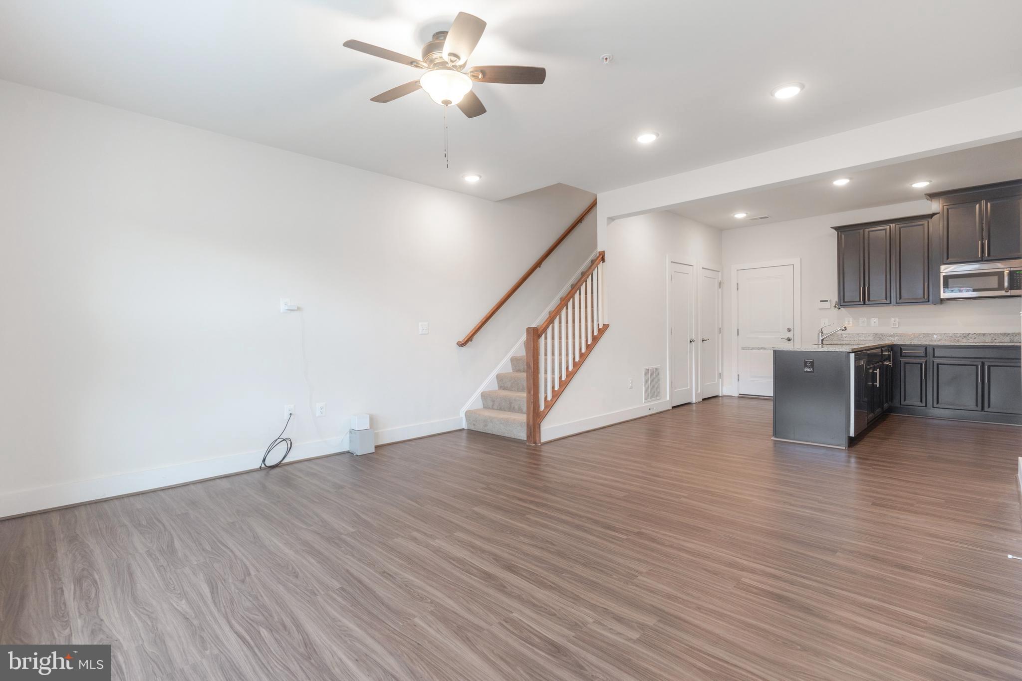 44730 Tiverton Square Ashburn, VA 20147 - Photo 4 of 39 a view of an empty room with wooden floor and a ceiling fan