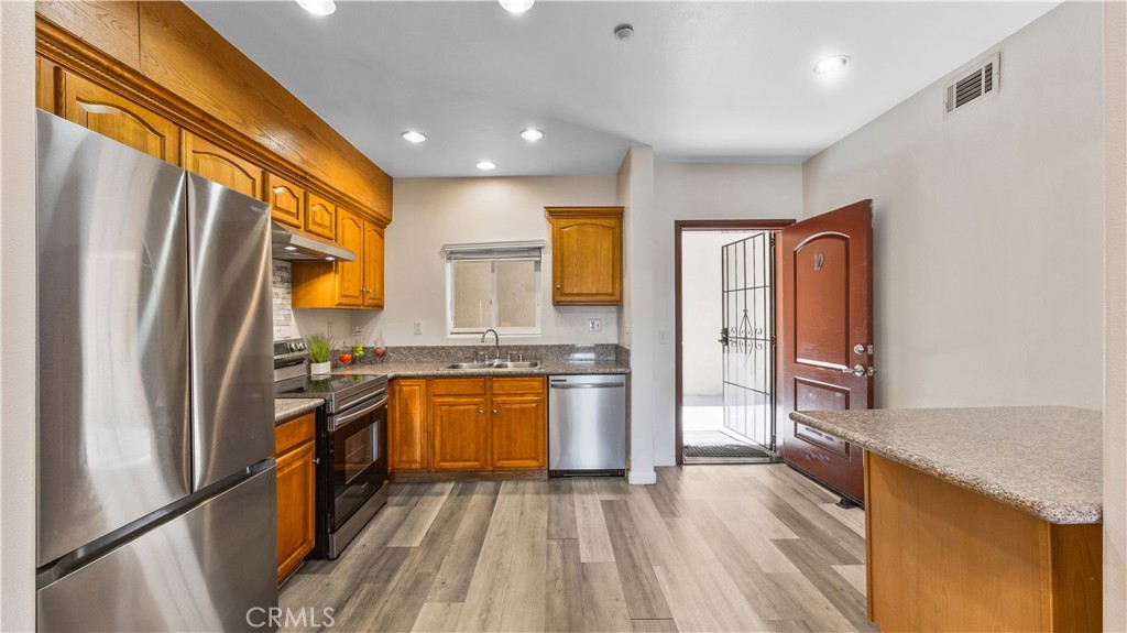 421 South Garfield Avenue, Unit 10 Monterey Park, CA 91754 - Photo 6 of 20 a kitchen with granite countertop stainless steel appliances a refrigerator stove top oven and sink