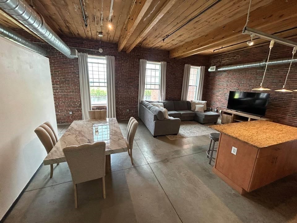 130 John Street, Unit 213 Lowell, MA 01852 - Photo 1 of 17 a living room with furniture a flat screen tv and windows