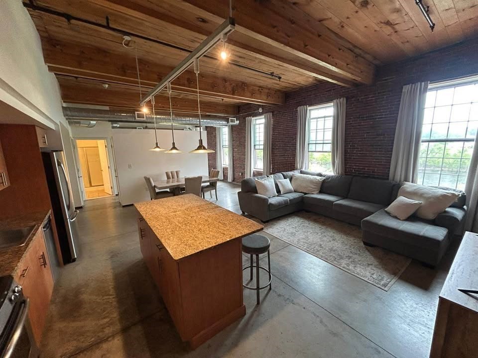 130 John Street, Unit 213 Lowell, MA 01852 - Photo 16 of 17 a living room with furniture and a flat screen tv
