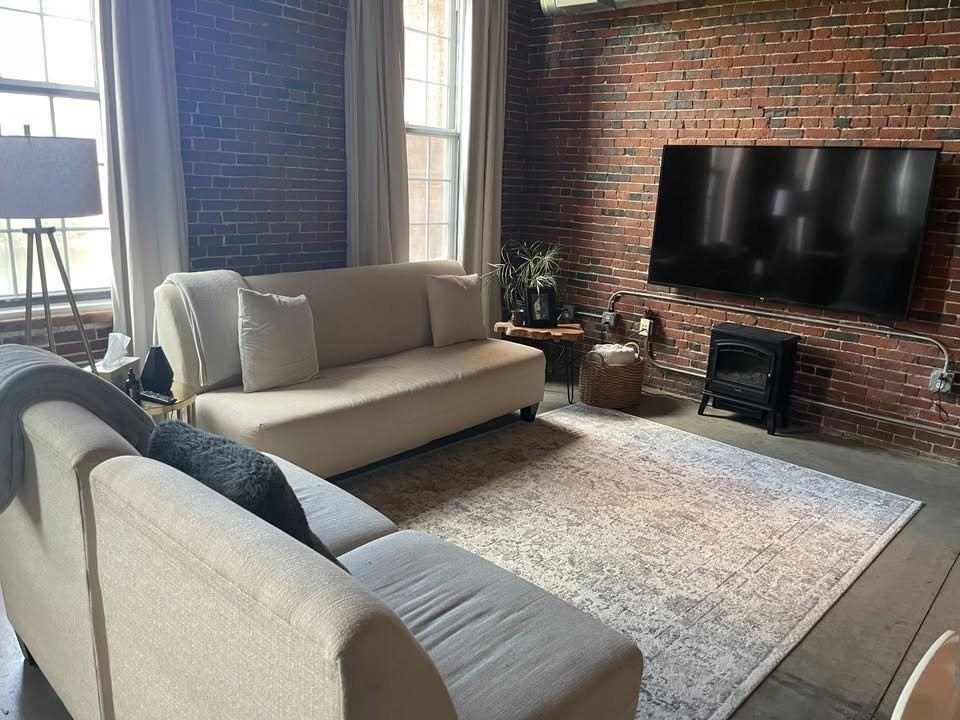 130 John Street, Unit 213 Lowell, MA 01852 - Photo 6 of 17 a living room with furniture and a flat screen tv