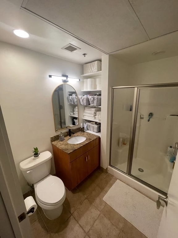 130 John Street, Unit 213 Lowell, MA 01852 - Photo 7 of 17 a bathroom with a granite countertop toilet sink and shower