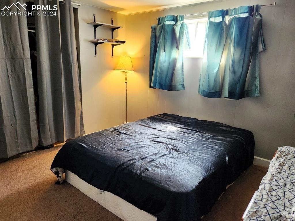 1509 Kickapoo Road Pueblo, CO 81001 - Photo 12 of 24 a bedroom with a bed and a chandelier