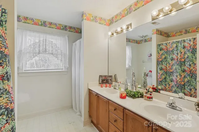 a bathroom with a double vanity sink mirror and shower