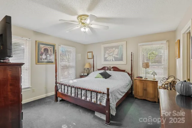 a bedroom with a bed chandelier and a window