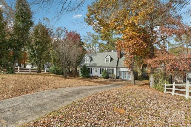 a front view of a house with a yard and trees
