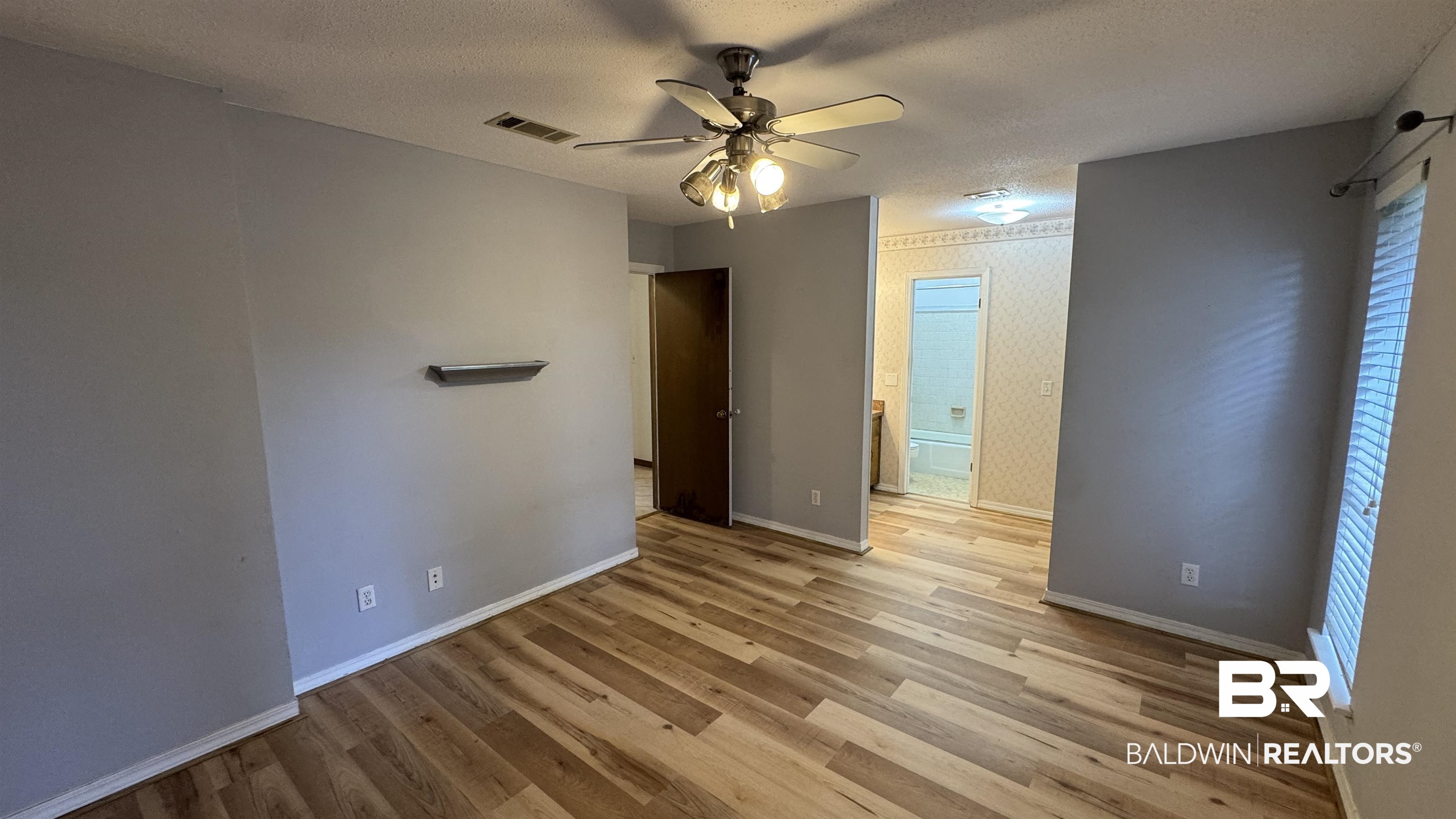 33370 Highway 98 Lillian, AL 36549 - Photo 30 of 58 Spacious interior with wood-finish flooring, a ceiling fan, and a neutral wall palette