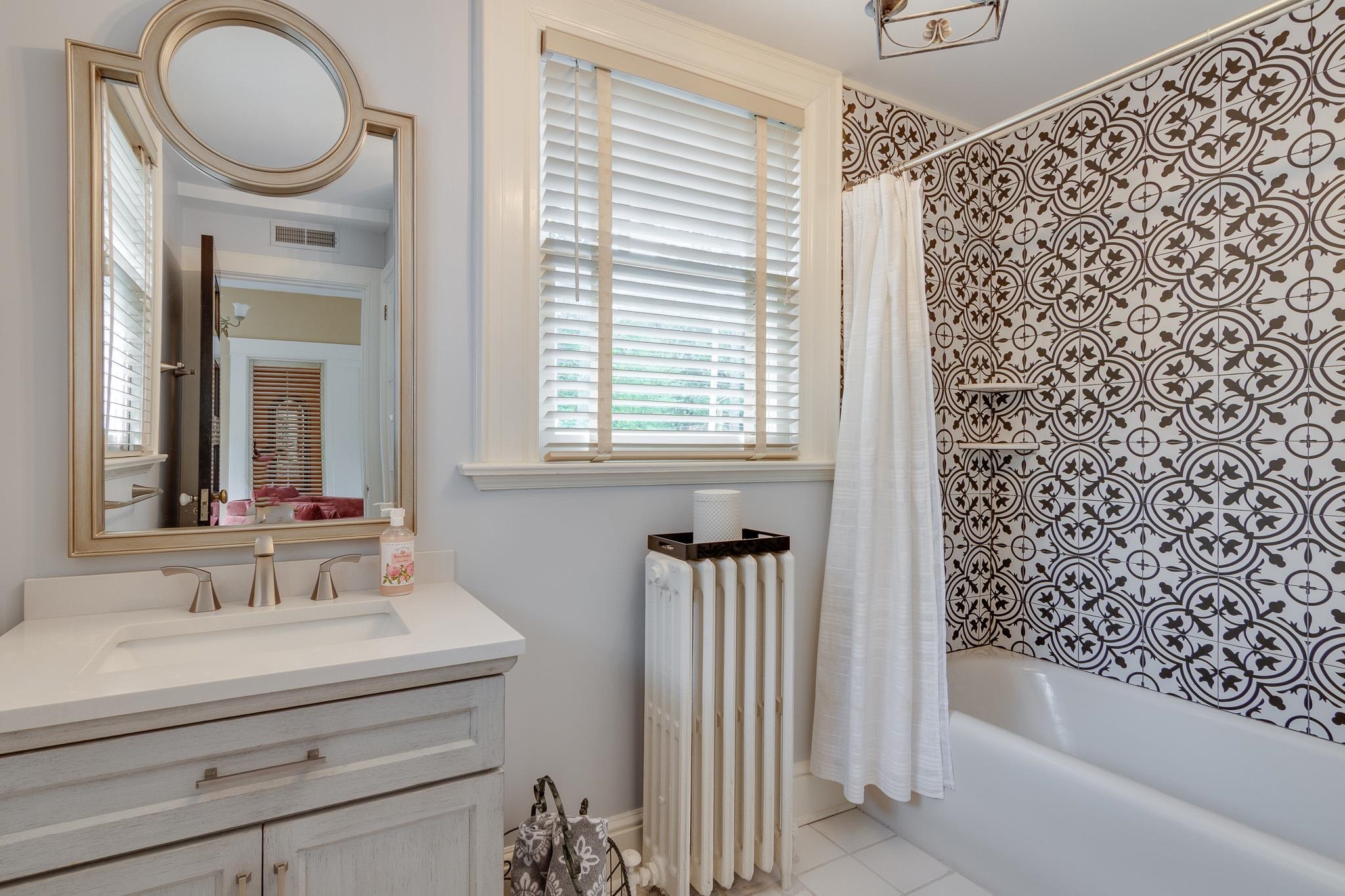 2221 Poplar Avenue Memphis, TN 38104 - Photo 26 of 40 a bathroom with a bathtub a sink and a window
