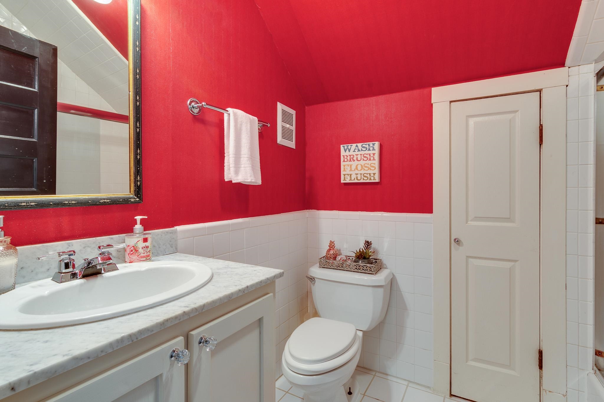 2221 Poplar Avenue Memphis, TN 38104 - Photo 32 of 40 a bathroom with a sink a toilet and mirror