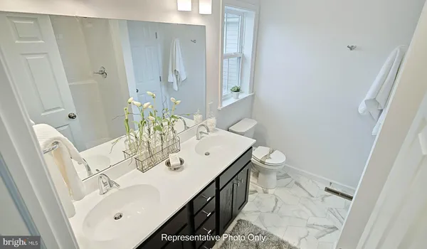 a en suite bathroom with a double vanity sink and a mirror