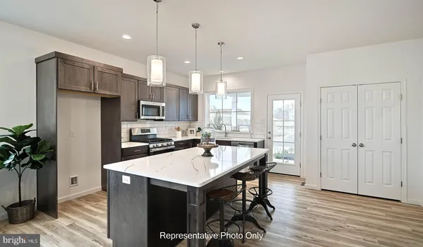 a kitchen with a refrigerator a sink dishwasher and a stove with wooden floor