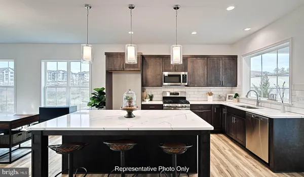 a kitchen with a stove a sink a kitchen island with a window and cabinets