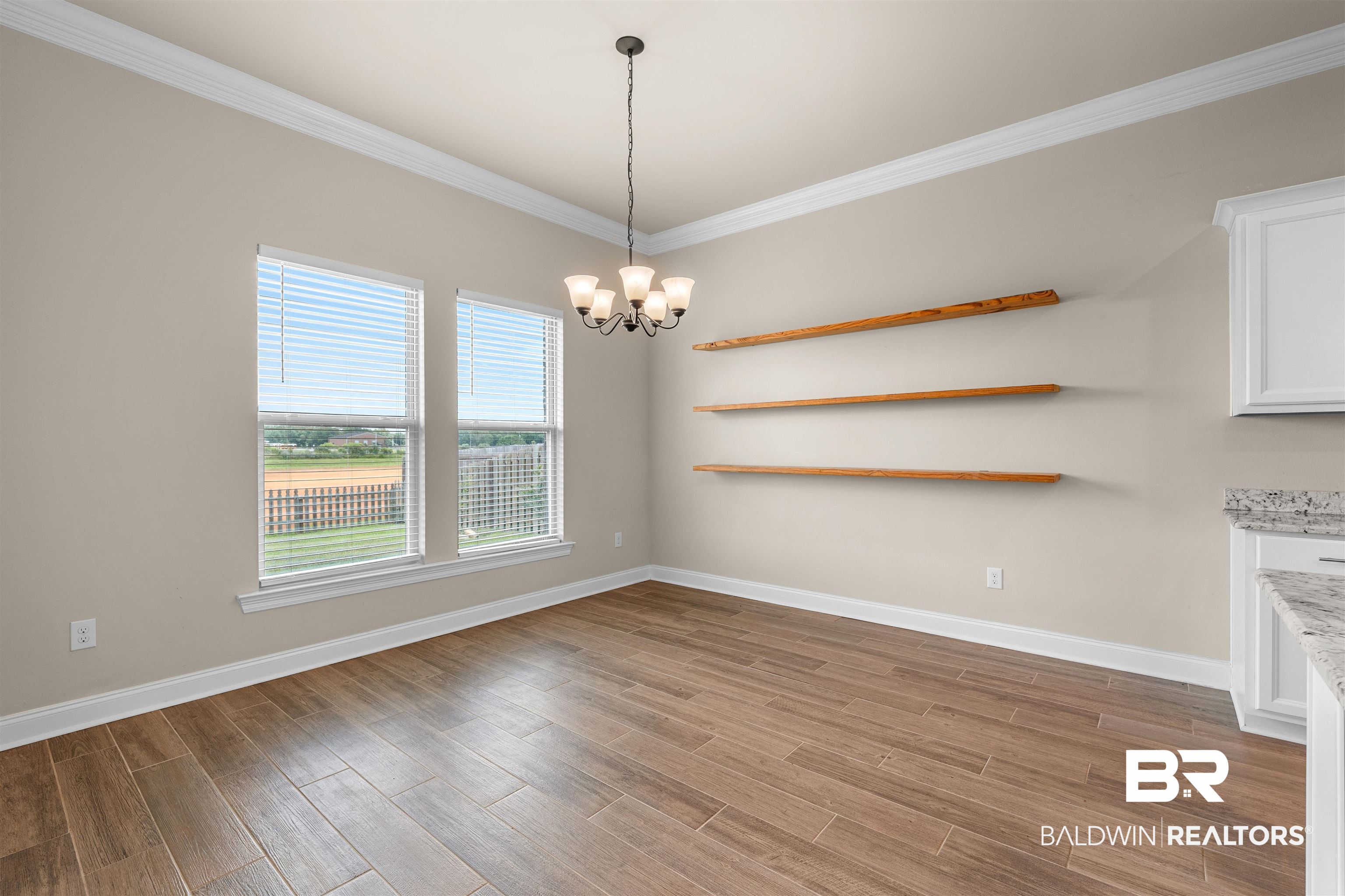 991 Dalton Circle Foley, AL 36535 - Photo 10 of 35 Unfurnished dining area featuring a chandelier, ornamental molding, and wood finished floors