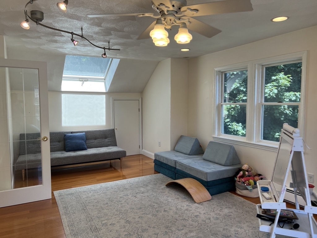 11 Garrison Road, Unit 1 Arlington, MA 02474 - Photo 23 of 42 a living room with furniture and a chandelier