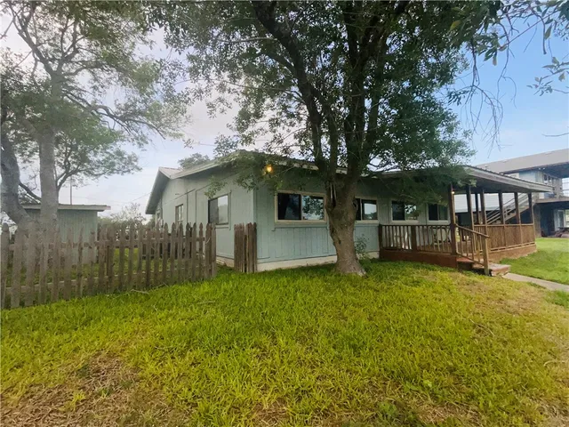 a white house that has a tree in front of it