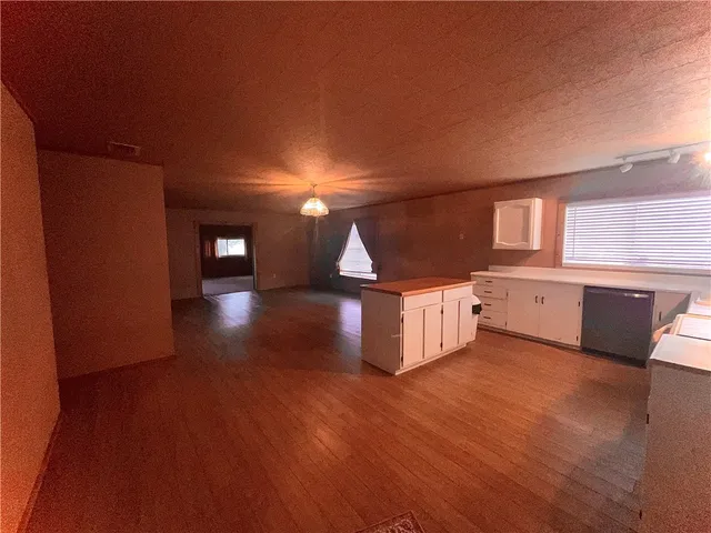 a view of a livingroom with wooden floor and stairs