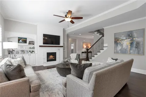 a kitchen with kitchen island granite countertop a dining table chairs refrigerator and wooden floor